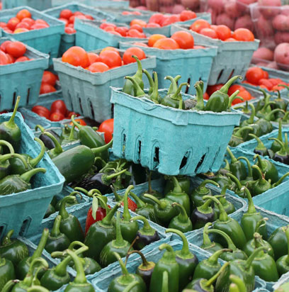 Long tables loaded with fresh produce offer a variety of fruits and veggies.