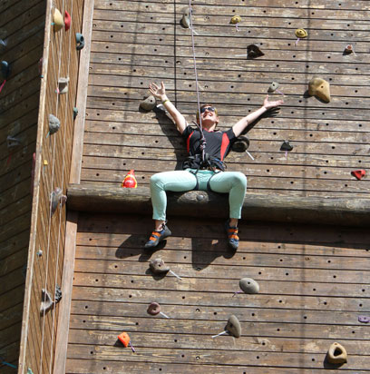 Eppley Recreation Center challenge course employee climbs with the roaming gnome.