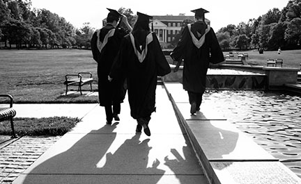 Sydney Bri and two friends walk McKeldin Mall at the University of Maryland in graduation regalia.